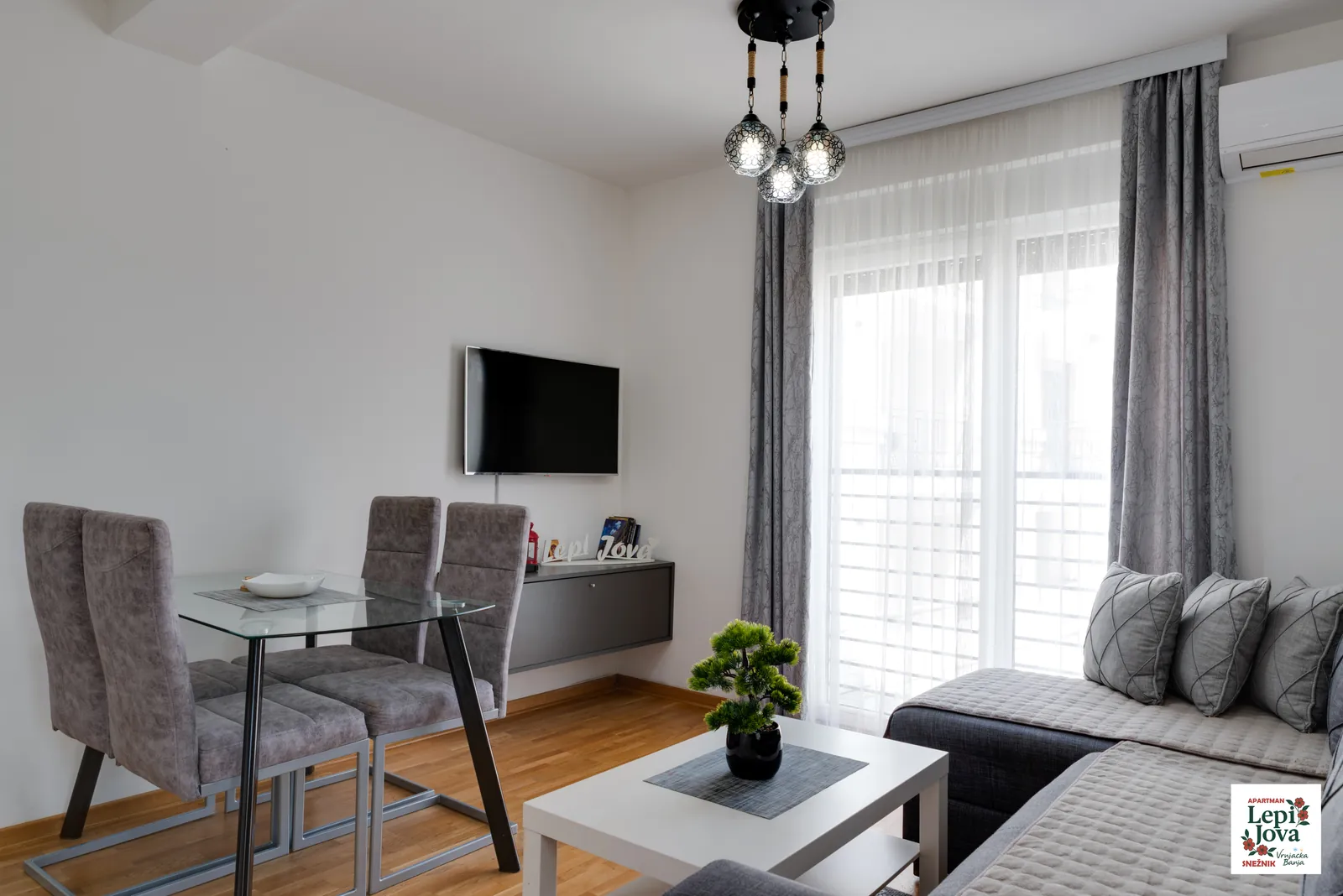 Dnevni boravak apartmana Snežnik sa televizorom i trpezarijskim stolom